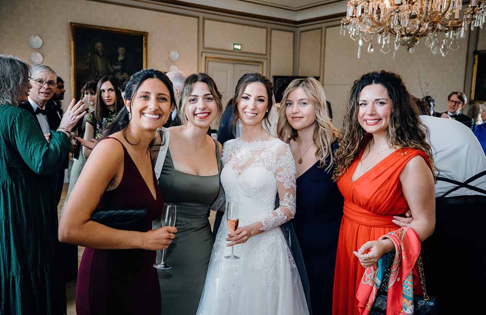 bruden med brudepiger i festsalen Bruden omgivet af sine brudepiger i festsalen på Holckenhavn Slot, klar til bryllupsfesten.